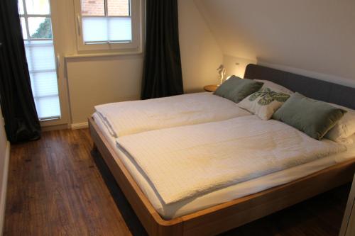 a large bed in a room with two windows at Ferienwohnung Emma in Jork
