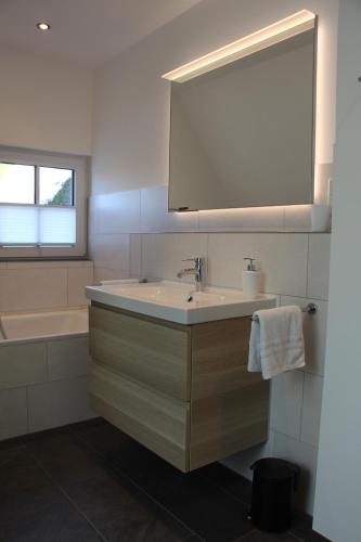 a bathroom with a sink and a bath tub at Ferienwohnung Emma in Jork