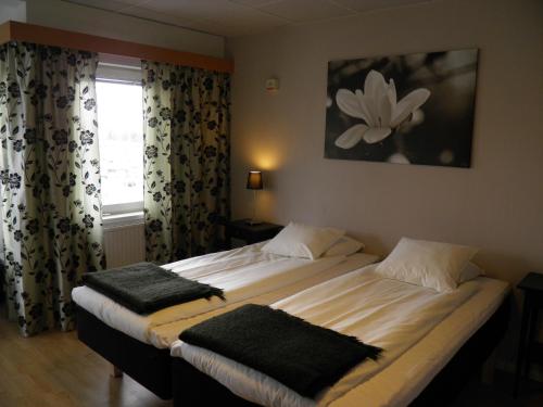 um quarto com 2 camas e uma janela com cortinas em Euroway Hotel em Gotemburgo