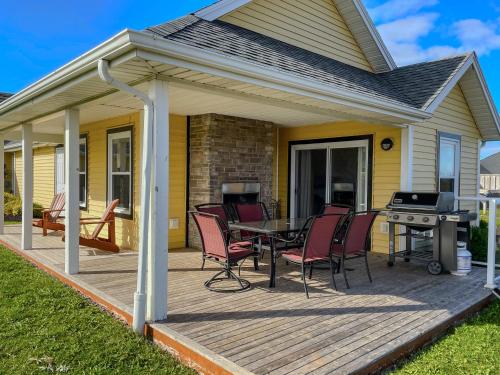 a deck with a table and chairs on a house at The Gables of PEI in Stanley Bridge