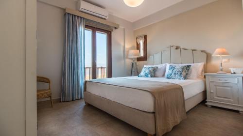 a bedroom with a large bed and a window at Blue Heart Luxury Suites II in Naxos Chora