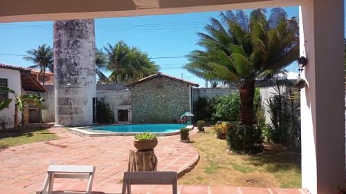 a courtyard with a swimming pool and a palm tree at Aconchego dos amigos in Beberibe