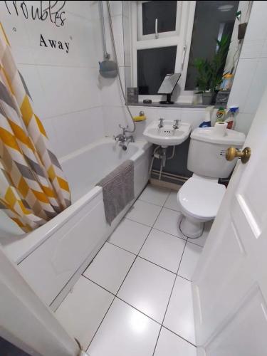 a bathroom with a toilet and a tub and a sink at Welcoming Home Close to Transport Links in Thornton Heath