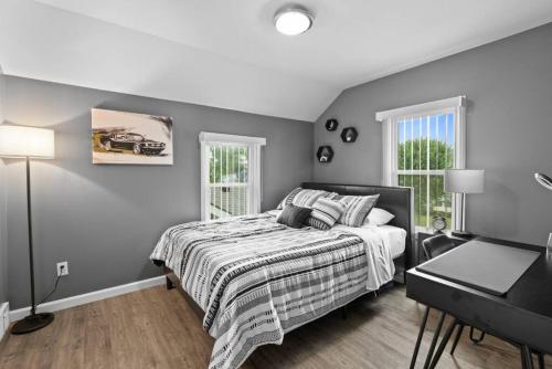 um quarto com uma cama, uma secretária e 2 janelas em Stylish luxury home in downtown Royal Oak Bham em Berkley