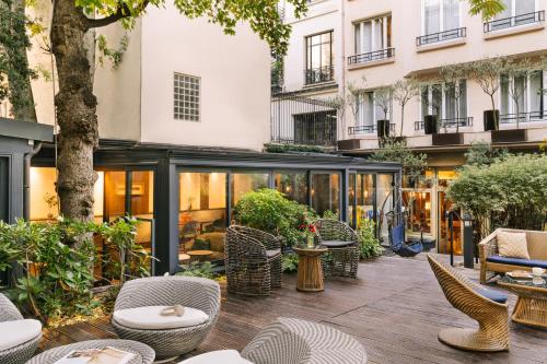 een terras met stoelen en tafels en een gebouw bij Atala powered by Sonder in Parijs