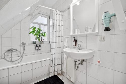 a white bathroom with a sink and a bath tub at Apartment am Hainich - 59m2, 4 Personen, Küche, Netflix, Parken, Hunde Willkommen in Hörselberg-Hainich