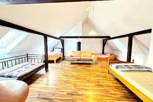 a attic room with two beds and a couch at City Apartments in Hof in Hof