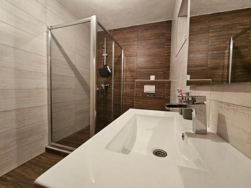 y baño con lavabo blanco grande y ducha. en Planinska kuća Ruža en Kupres