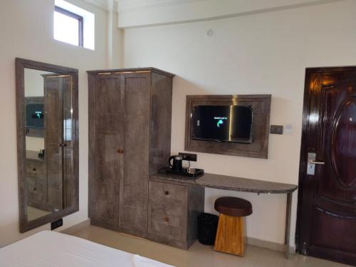 a bathroom with a sink and a tv on a wall at Hotel AK International - Chennai in Chennai