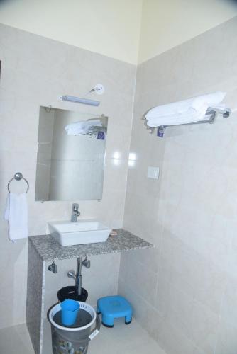 W łazience znajduje się umywalka i lustro. w obiekcie The Royal Residency w mieście Rajgir