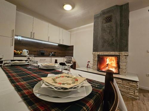 cocina con mesa de comedor y chimenea en Planinska kuća Ruža en Kupres