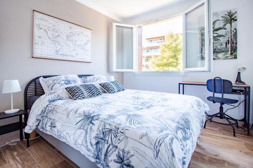 a bedroom with a bed with a blue and white comforter at T3 Calme Balcon Climatisation et Parking gratuit - Netflix - Stade Vélodrome in Aix-en-Provence