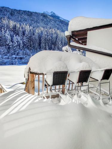 a group of chairs sitting in the snow at Doug's Mountain Getaway - 'Top Two Floors' in Fulpmes