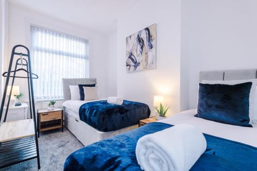 a bedroom with two beds and a window at Sleek and Stylish 3 BR Home Mcr in Manchester