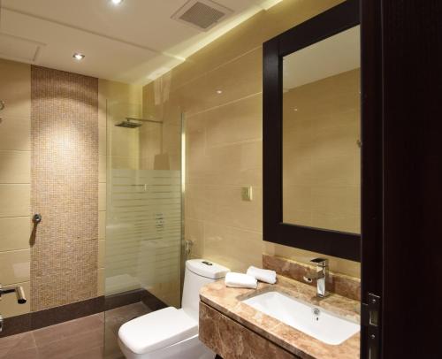 a bathroom with a toilet and a sink and a mirror at Hayat Heraa Hotel in Jeddah