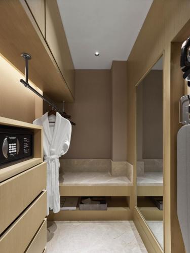 a small room with a bed and a mirror at Hilton Shanghai Songjiang Guangfulin in Songjiang
