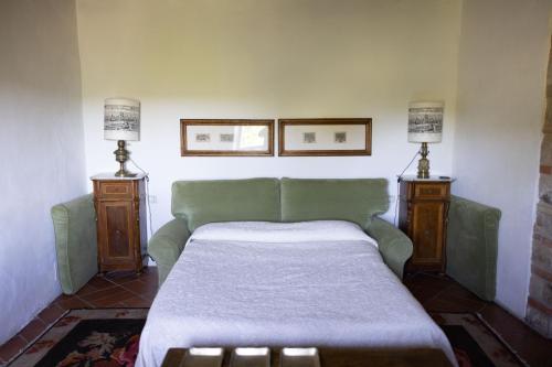 a bedroom with a green bed and two lamps at Castello di Bibbione in San Casciano in Val di Pesa