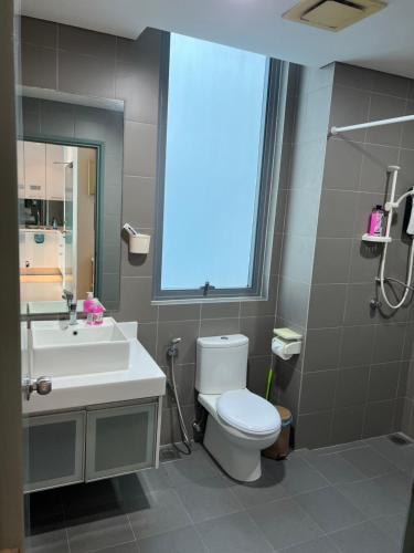 a bathroom with a toilet and a sink and a window at Summer suites KLCC by cozy stay in Kuala Lumpur