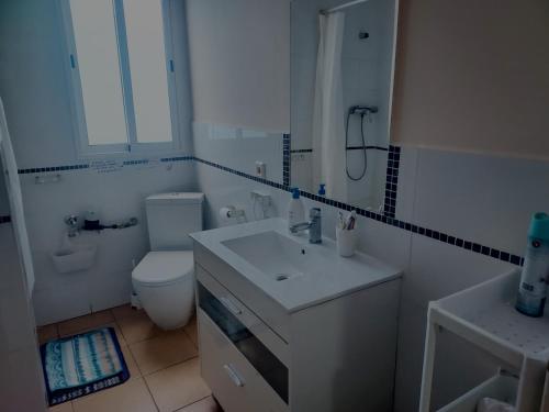 Baño blanco con lavabo y aseo en Cozy Private Room en Valencia