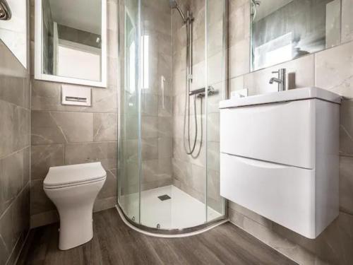 a bathroom with a toilet and a glass shower at Pass the Keys Spacious modern home with parking in Exmouth in Exmouth