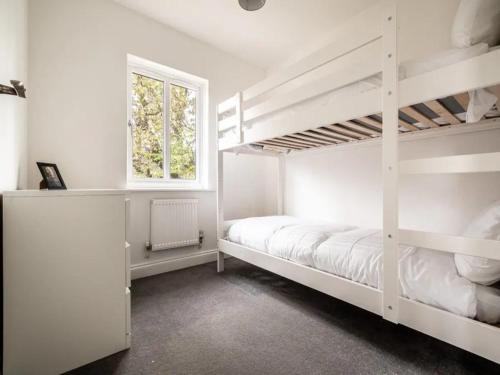 um quarto com 2 beliches e uma janela em Pass the Keys Spacious modern home with parking in Exmouth em Exmouth
