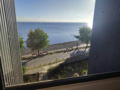 a view of the ocean from a window of a building at Departamento a orillas del lago in Llanquihue