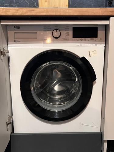 a washing machine in a kitchen with its door open at Astro Apart in Kielce