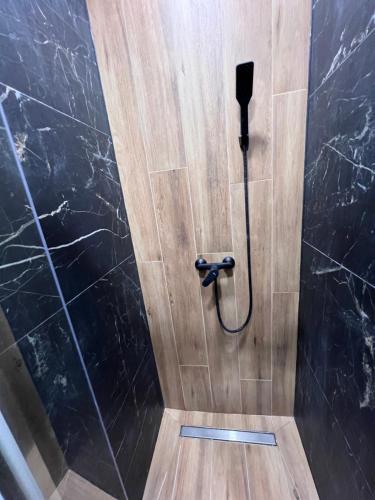 a shower in a bathroom with a black wall at Astro Apart in Kielce