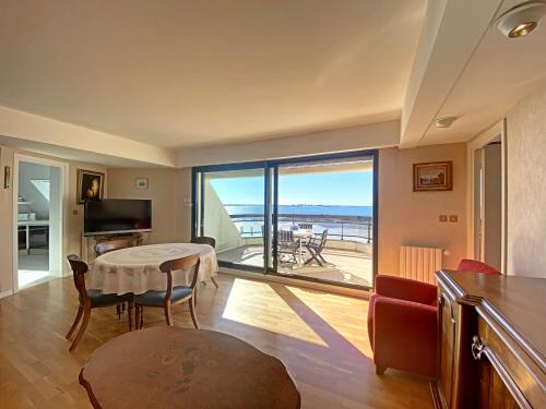 a living room with a table and a view of the ocean at RÉF 318 - LARMOR-PLAGE spacieux type 3 pleine vue mer avec terrasse, ascenseur, parking in Larmor-Plage
