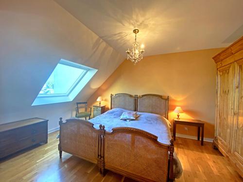 a bedroom with a bed and a chandelier at RÉF 318 - LARMOR-PLAGE spacieux type 3 pleine vue mer avec terrasse, ascenseur, parking in Larmor-Plage