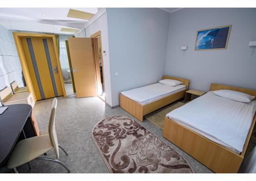 a hotel room with two beds and a desk and a desk at Olympic Sport in Podgortsy