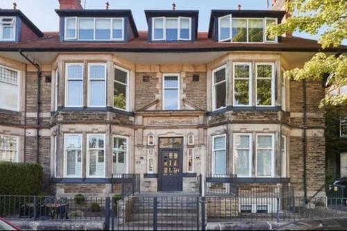 a large brick house with white windows at Town Centre Apartment Harrogate in Harrogate