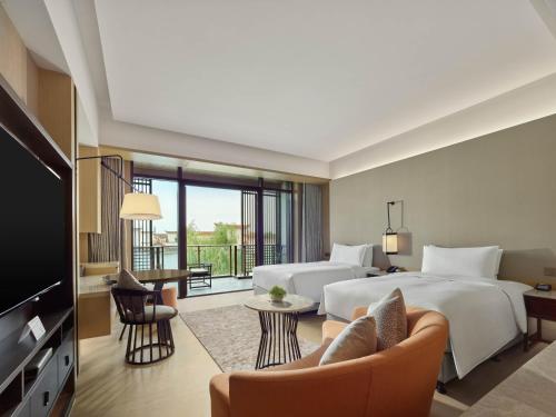 a hotel room with two beds and a balcony at Hilton Shanghai Songjiang Guangfulin in Songjiang