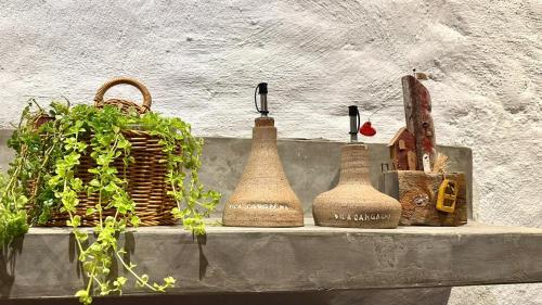 卡莫辛的住宿－Vila Cangalha，一个带三瓶木瓶子和篮子的架子