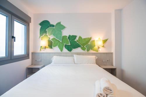 1 dormitorio con 1 cama blanca grande y 2 lámparas en IVY HOUSE, en Sevilla