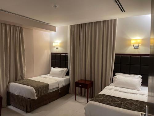 a hotel room with two beds and a table at Massayef Al Khobar 2 in Al Khobar