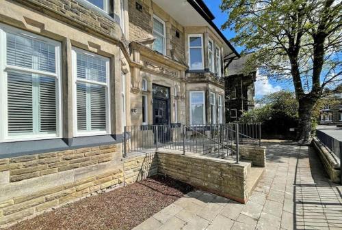 a brick house with a porch and a fence at Town Centre Apartment Harrogate in Harrogate