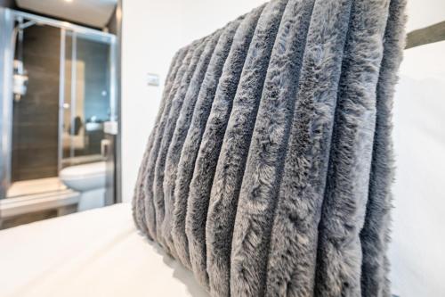 a gray towel hanging on a wall in a bathroom at Luxury 4 Beds 2 Bath Near City Centre Freeparking in Southampton