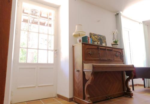 een kamer met een piano naast een deur bij La Tour de Coron in Belley