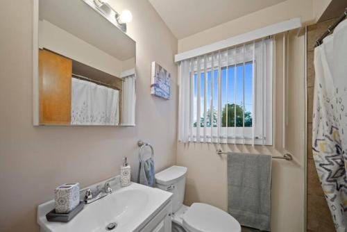 baño con aseo y lavabo y ventana en Modern Cozy 1 Bedroom Apartment in Shelby Township, en Shelby