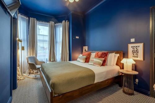 a bedroom with a large bed with blue walls at The Wellesley in Belfast