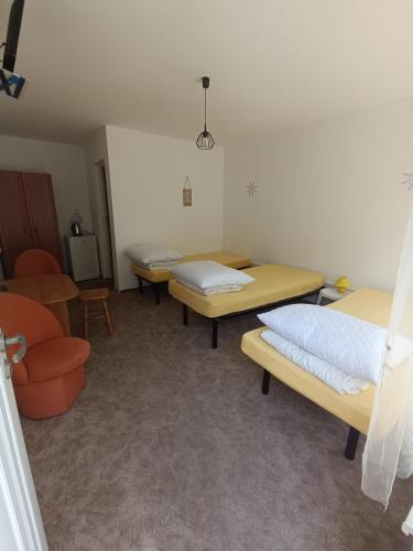 a hospital room with two beds and a chair at Pokoje Gościnne u Kasi in Międzywodzie