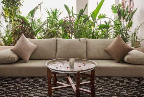 a couch with a table in a room with plants at Riad N'S & Spa in Marrakech