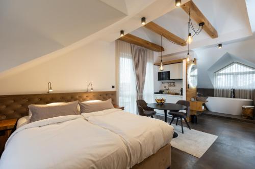 Un dormitorio con una cama grande y una mesa con sillas. en Kavenija apartmaji - Free Parking, en Maribor
