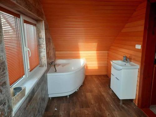uma casa de banho com uma banheira branca e um lavatório. em Domček v Tatrách em Poprad