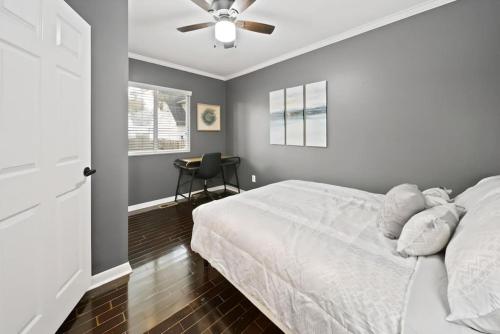 - une chambre avec un lit blanc et un ventilateur de plafond dans l'établissement Stylish Luxury 3bd home in Downtown Birmingham, à Birmingham