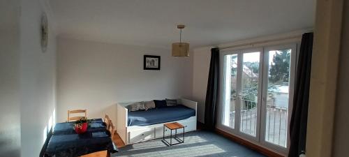 a small bedroom with a bed and a balcony at Appart à Versailles, 2 à 4 pers, avec parking in Versailles