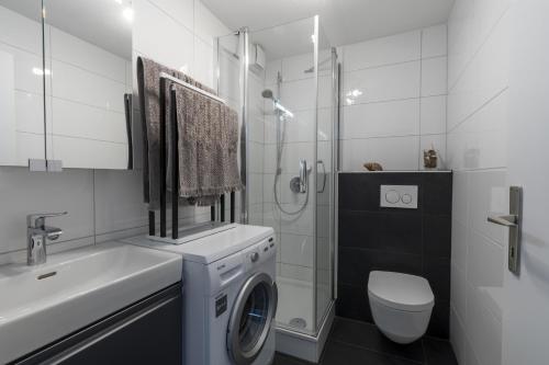 ein Badezimmer mit einer Waschmaschine und einem WC in der Unterkunft Sagenhafter Ausblick in Bad Peterstal-Griesbach