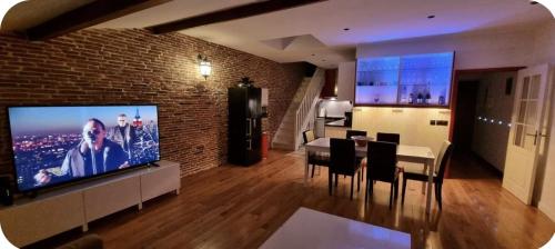 a living room with a television and a table and chairs at Loft 80m2 en plein cœur de la vieille ville 3 étoiles in Toulon