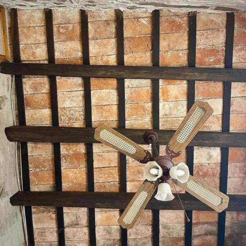 a ceiling fan on top of a bed at Posada San Gabriel in Colonia del Sacramento